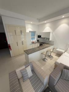 a living room with a couch and a kitchen at Hawana Studio SL-3 in Wādī Khasbar