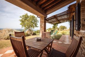 a wooden table and chairs on a patio at La Casina dei Lapi in Catabbio