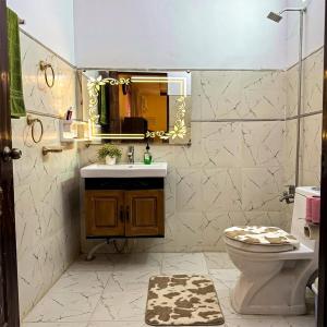 a bathroom with a sink and a toilet and a mirror at Charming Home banglow in Karachi +36 photos