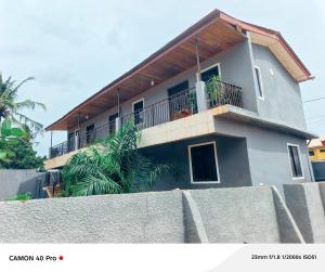 a house with a balcony and a fence at 0YE' Hotel in Ashalebotwe