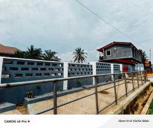 a fence next to a building with a house at 0YE' Hotel in Ashalebotwe