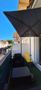 a pool with an umbrella and chairs on a balcony at Le vitrail d'Arcachon - Appt Spacieux Terrasse Ménage draps inclus in Arcachon