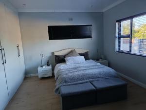 a bedroom with a bed and a flat screen tv at Almond Place in Tokai +20 photos