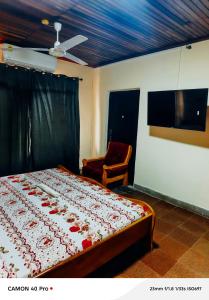 a bedroom with a bed and a chair at 0YE' Hotel in Ashalebotwe