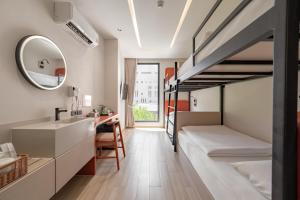 ein Schlafzimmer mit Etagenbetten, Waschbecken und Spiegel in der Unterkunft Jace Siam Hotel in Bangkok + 68 Fotos