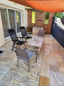 a patio with chairs and a wooden table on a patio at Bienvenue chez nous ! in Combrand