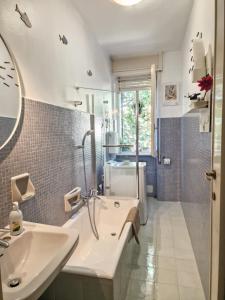 a bathroom with a sink and a tub and a mirror at Casa Orso in Abbadia Lariana