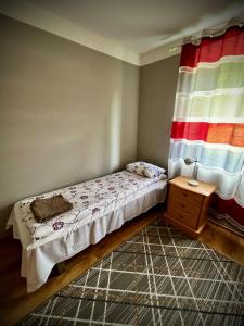 a small bedroom with a bed and a window at Vormsi Ohvitseride Maja korter nr 2 in Hullo +4 photos