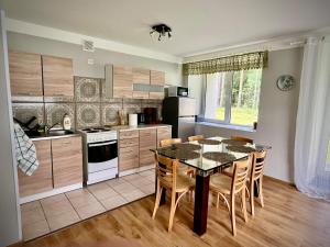 a kitchen with a table and chairs in a kitchen at Vormsi Ohvitseride Maja korter nr 2 in Hullo