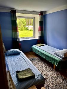 two beds in a room with a window at Vormsi Ohvitseride Maja korter nr 2 in Hullo