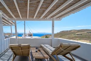 a patio with two chairs and a table on a balcony at Sea Houses SERIFOS in Rámos