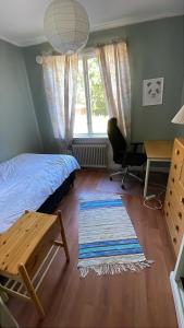 a bedroom with a bed and a desk and a window at 5ans rum Gunghästen in Skellefteå