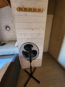 a fan sitting in a room next to a bed at Bienvenue chez nous ! in Combrand +2 photos