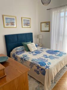 a bedroom with a bed with a blue head board at Casa Solace in Almada