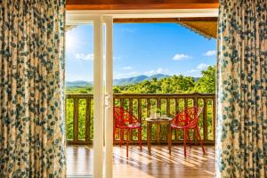 a room with a balcony with a table and chairs at Nature Trails Rock Valley, Goa in Ponda