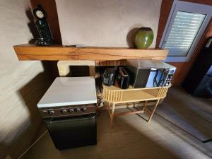 a small kitchen with a stove and a microwave at Bienvenue chez nous ! in Combrand