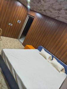 a bedroom with a bed with a wooden wall at krishna yadav homestay in Hospet +19 photos