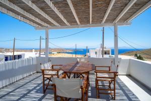 a table and chairs on a balcony with a view of the ocean at Sea Houses SERIFOS in Rámos