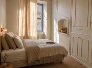 a bedroom with a bed and a window at Maison du temps lent Centre historique en Arbois Escapade Romantique in Arbois