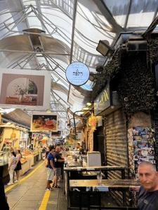 a group of people standing in a market at Narkis - A Boutique Stay in the Heart of Jerusalem in Jerusalem