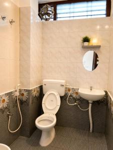a bathroom with a toilet and a sink at La Muthu Beach Stay in Pondicherry