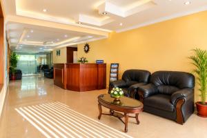a lobby with a leather couch and a table at Hotel Sandra Palace in Thekkady