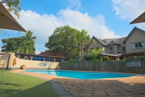 a swimming pool in front of a house at Lakeview Cabanas - Unit 5 in St Lucia
