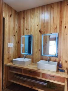 a bathroom with two sinks and two mirrors at Coffee Myhome in Kon Rung (1)