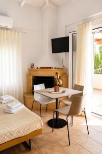 a living room with a table and a bed at Lagouvardos Beach Apartments in Marathopoli