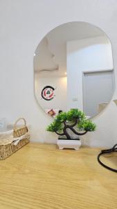 a room with a round mirror and a bonsai tree at ฮ่องเต้รักไทยรีสอร์ท in Ban Rak Thai