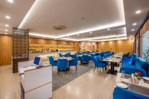 a dining room with tables and blue chairs at Lords Inn Katra in Jāmb