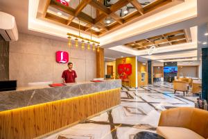 a man standing in the lobby of a hotel at Lords Inn Katra in Jāmb