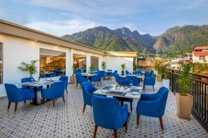 a restaurant with blue chairs and tables and mountains at Lords Inn Katra in Jāmb