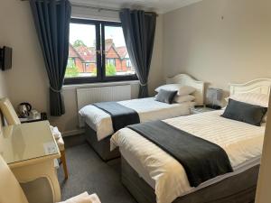 a hotel room with two beds and a window at Lomond Villa in Balloch