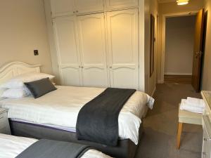 a bedroom with two beds and a closet at Lomond Villa in Balloch
