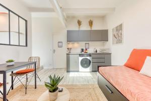 a living room with a bed and a table and a kitchen at Bright studio - RER B - Plateau de Saclay in Palaiseau +28 photos
