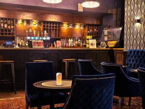 a bar with chairs and a table in a room at The Crown Hotel in Stone
