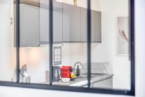 a kitchen counter with a sink and a mirror at Bright studio - RER B - Plateau de Saclay in Palaiseau