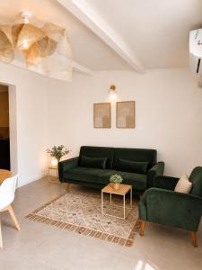 a living room with a green couch and a table at La Maison du Cerisier in Manosque