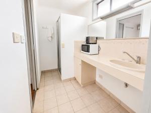 a bathroom with a sink and a microwave at Beaconsfield Lodge Motel in Beaconsfield +46 photos
