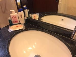 een badkamermeubel met een wastafel en een ligbad bij فندق الأصيل ألوان الفندقية in Mekka