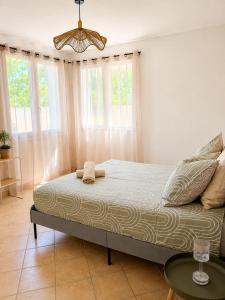 a bedroom with a bed and a table and windows at La Maison du Cerisier in Manosque