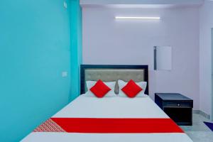 a bedroom with a bed with red pillows at Hotel O City View in Dānāpur