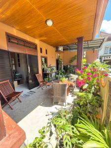 a patio with chairs and a table and flowers at Mocca Guest House in Banyuwangi