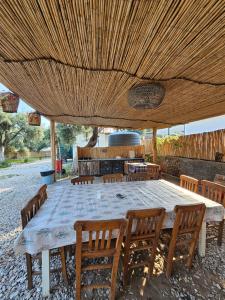 a large table and chairs under a wooden ceiling at Ruina Glamping in Mezgit