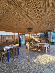 a restaurant with tables and chairs and a large ceiling at Ruina Glamping in Mezgit