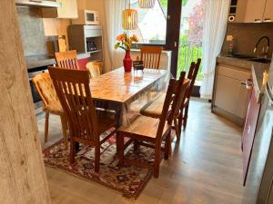 a kitchen and dining room with a wooden table and chairs at EifelRuhe 5 - Platz für bis zu 8 Personen, Hunde willkommen in Schleiden