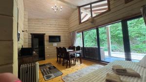 a room with a dining room with a table and chairs at Hotel Berloga-Sinevir in Synevyrsʼka Polyana