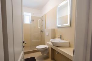 a white bathroom with a toilet and a sink at Vila Sibiu in Sibiu +44 photos
