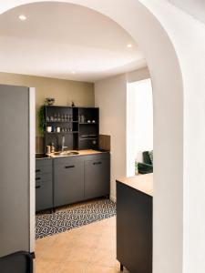 an archway in a kitchen with a sink at La Maison du Cerisier in Manosque